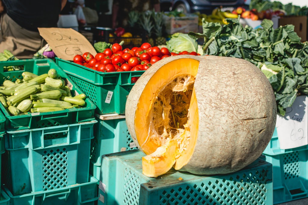 Marktstand mit regionalen Produkten: Kürbis, Tomaten, Zucchini, Blumenkohl