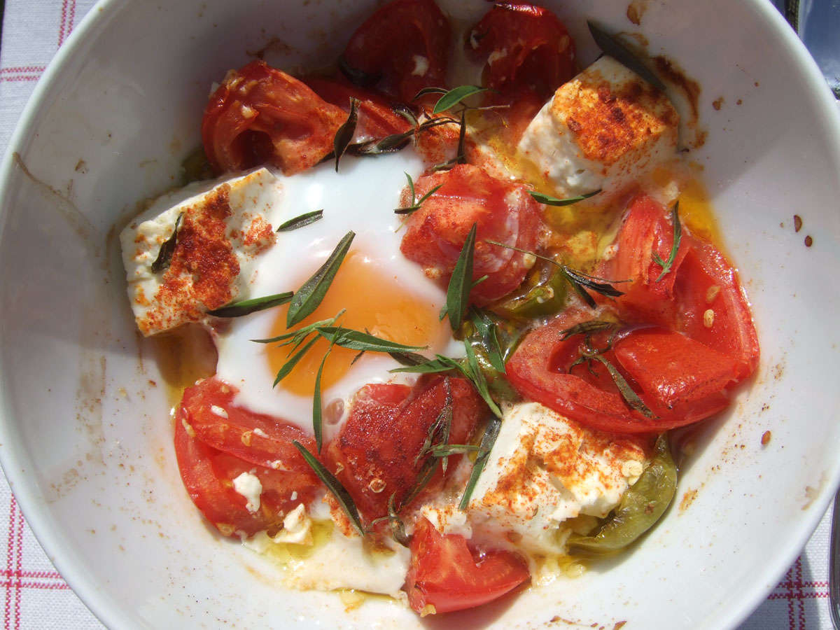 Gebackener Schafskäse mit Tomate, Ei und Chili Peperoni in einer Porzellanschüssel