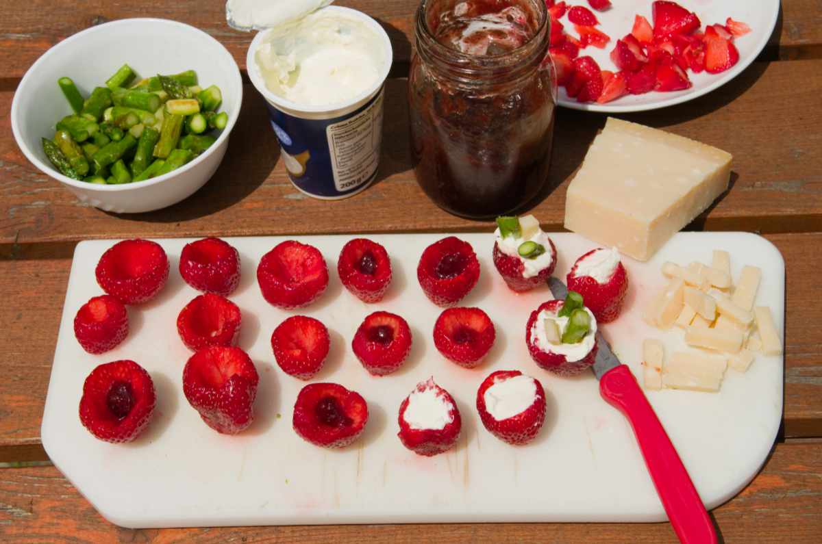 Zubereitung gefüllter Erdbeeren mit Parmesan, Creme Fraiche, grünem Spargel und Rucola